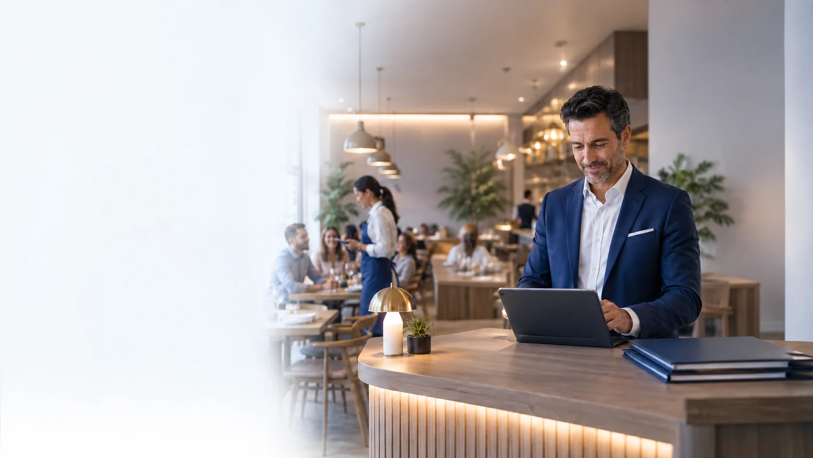 Restaurant manager using a tablet inside a busy restaurant